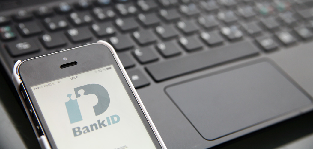 Ett tangentbord och en mobiltelefon på som visar BankID på skärmen